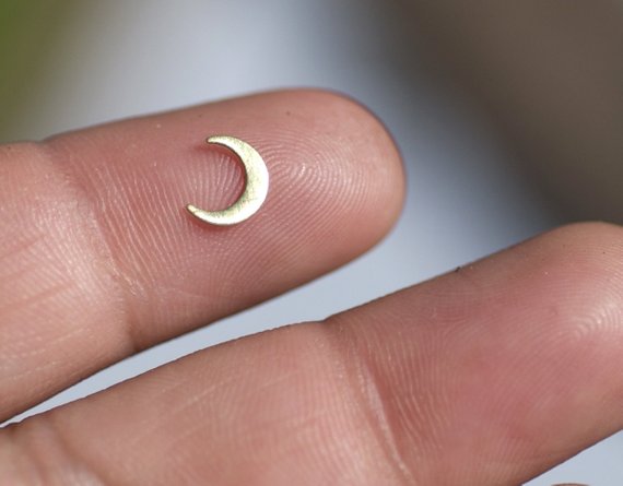 a tiny crescent moon on a finger